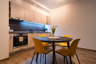 a kitchen with a black table and yellow chairs at Sunny Penthouse with Mountain Views and 180 degrees Terrace in Sofia