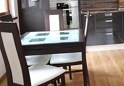 a glass table with two chairs and a stove at Rila Morning in Borovets