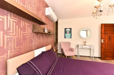 a bedroom with a purple bed and a pink chair at Cozy house in the heart of Pirin mountain in Razlog