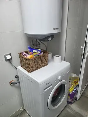 a washing machine with a basket on top of it at Cozy house in the heart of Pirin mountain in Razlog