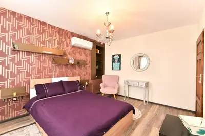 a bedroom with a purple bed and a pink chair at Cozy house in the heart of Pirin mountain in Razlog