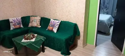 a green couch and a table in a room at Бутикови стаи за гости- Felicita in Kyustendil