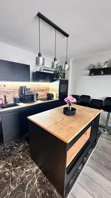 a kitchen with a counter with a vase of flowers on it at Апартамент за гости Noa Sift in Velingrad