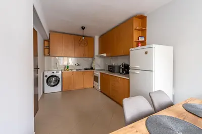 a kitchen with wooden cabinets and a white refrigerator at Vitoshкa Urban Stay in Sofia