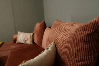 a brown couch with two pillows on it at Vitoshкa Urban Stay in Sofia