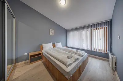 a bedroom with a large bed with a window at VEGA Apartments - Metro in Sofia