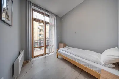 a bedroom with a bed and a large window at VEGA Apartments - Metro in Sofia