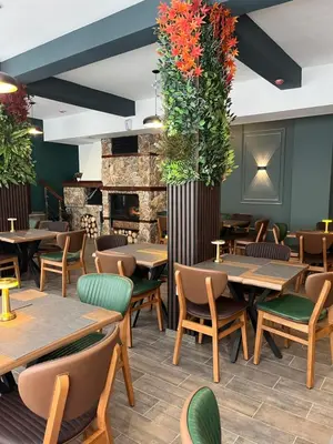a restaurant with tables and chairs and a fireplace at Hotel Rodope in Pamporovo