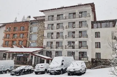a snow covered parking lot in front of a hotel at Hotel Rodope in Pamporovo
