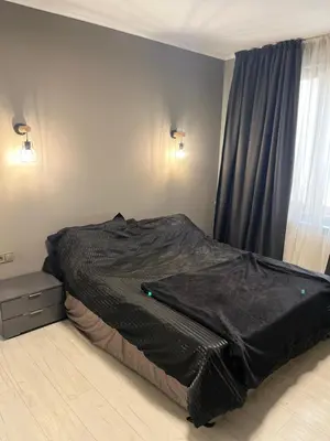 a bed with a black comforter in a bedroom at Apartment in city center in Sofia
