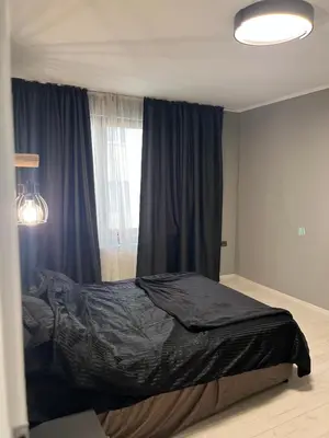 a bedroom with a bed with black sheets and a window at Apartment in city center in Sofia