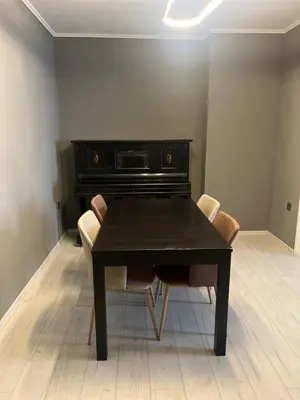 a dining room table with chairs and a piano at Apartment in city center in Sofia