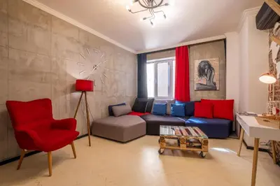 a living room with a couch and a red chair at 2 Apartments 15 Seconds from Main street in Sofia
