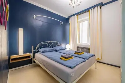 a blue bedroom with a bed with blue walls at 2 Apartments 15 Seconds from Main street in Sofia