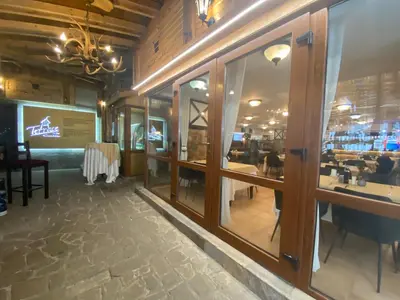 a restaurant with glass windows and a dining area at Castle Inn Pamporovo 2 Bedroom Apartment in Pamporovo