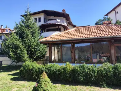 a house with a conservatory with a roof at Къща за гости Свети Георги in Pamporovo