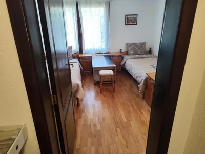 a room with a bed and a table and a desk at Къща за гости Свети Георги in Pamporovo