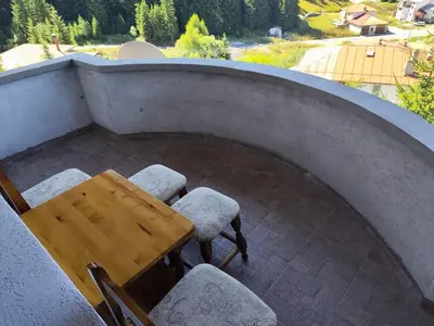 a table and chairs on a balcony with a view at Къща за гости Свети Георги in Pamporovo