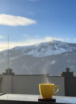 a yellow coffee cup sitting on a table with a mountain at Cozy Central Apartment-Welcome Coffee and Wine in Sofia