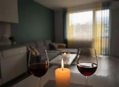 two glasses of wine and a candle on a table at Cozy Central Apartment-Welcome Coffee and Wine in Sofia