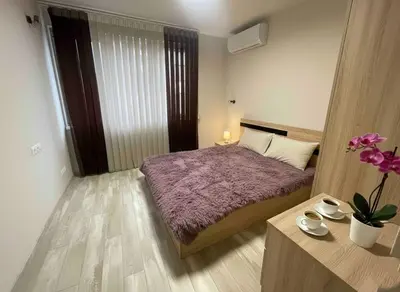 a bedroom with a bed and a table with flowers at Cozy Central Apartment-Welcome Coffee and Wine in Sofia