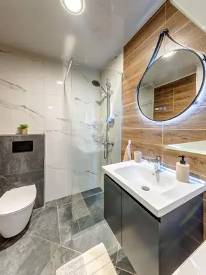 a bathroom with a sink and a toilet and a mirror at Stylish 1BR in the Heart of Town in Smolyan