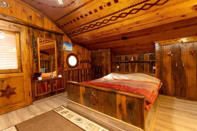 a bedroom with a bed in a wooden cabin at Къща за Гости Слънце in Breze