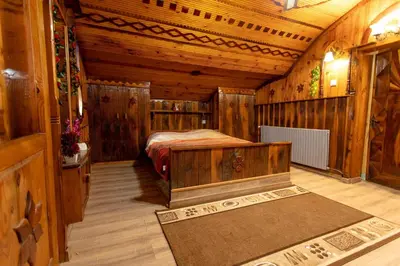 a bedroom with a bed in a wooden cabin at Къща за Гости Слънце in Breze