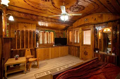 a bedroom with wooden walls and a ceiling at Къща за Гости Слънце in Breze