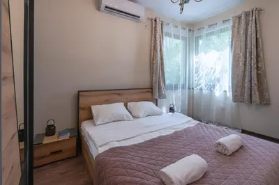 a bedroom with a bed with white sheets and a window at Nice 1 BDR apartment next to National Palace of Culture in Sofia