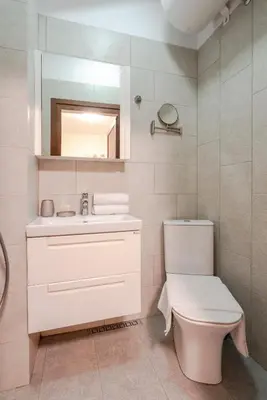 a bathroom with a toilet and a sink and a mirror at Nice 1 BDR apartment next to National Palace of Culture in Sofia