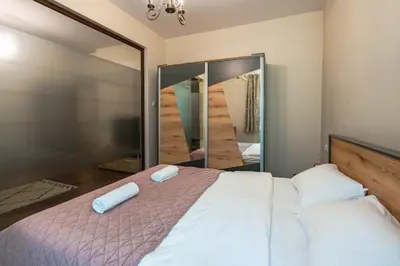 a bedroom with a bed and a large mirror at Nice 1 BDR apartment next to National Palace of Culture in Sofia