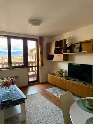 a living room with a large television and a table at Pirin Sense Apartment Home2Host in Bansko