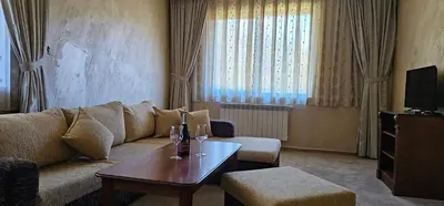 a living room with a couch and a table at Свети Георги хотел и ресторант in Govedartsi