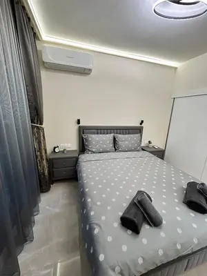 a bedroom with a bed with two black shoes on it at Le bijou Lauta Forest in Plovdiv