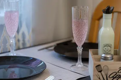 two glasses of champagne on a table with a bottle of milk at Two Vintage Apartments by NDK and Vitosha Blvd with Free Parking in Sofia