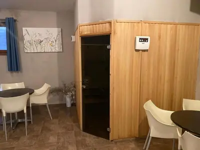 a room with a wooden cabinet with a table and chairs at The View Bansko in Bansko