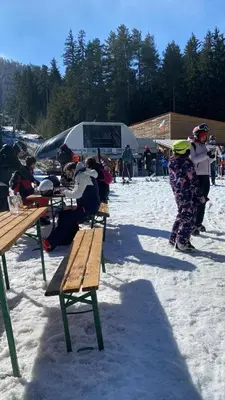 a group of people sitting at picnic tables in the snow at The View Bansko in Bansko