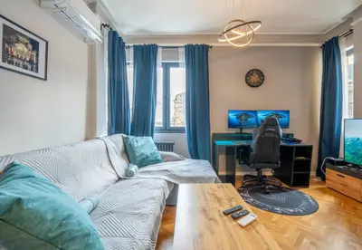 a living room with a couch and a desk at Stylish 2BDRM Apartment in the Very Heart of Sofia in Sofia