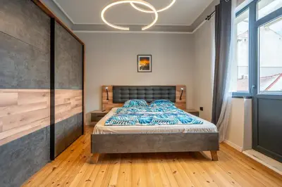 a bedroom with a bed and a large window at Stylish 2BDRM Apartment in the Very Heart of Sofia in Sofia