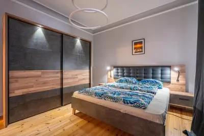 a bedroom with a large bed and a chandelier at Stylish 2BDRM Apartment in the Very Heart of Sofia in Sofia