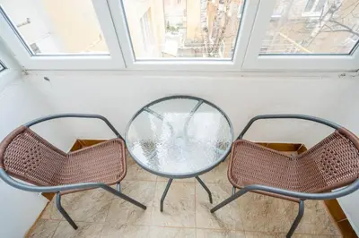 two chairs and a glass table in a room at Stylish 2BDRM Apartment in the Very Heart of Sofia in Sofia