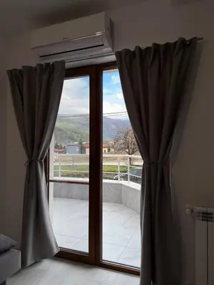 a window with curtains in a room with a view at Bianca Guest House Sapareva banya in Sapareva Banya