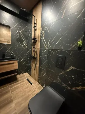 a bathroom with a shower with a bench in it at Bianca Guest House Sapareva banya in Sapareva Banya