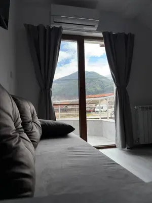 a bedroom with a bed and a window with a view at Bianca Guest House Sapareva banya in Sapareva Banya