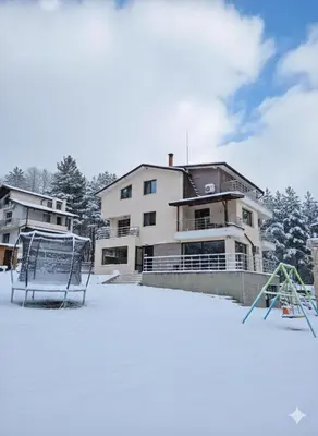 a house in the snow with a playground at Guest House Vanessa 2 in Gulubovo
