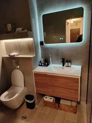 a bathroom with a toilet and a sink and a mirror at AMur Deluxe Apartment in Sofia