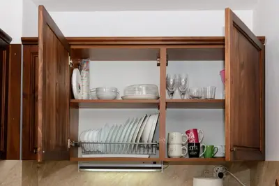 a cabinet with plates and dishes in it at Your studio at Winslow Infinity in Bansko