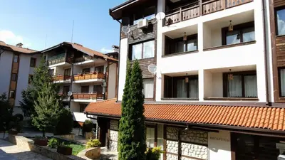 an apartment building with a tree in front of it at Your studio at Winslow Infinity in Bansko