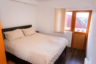 a bedroom with a bed and a window with a view at Къща за гости Рилски рай in Samokov